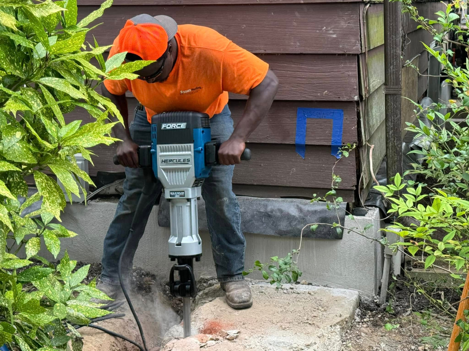 SOMD Hauling worker breaking a concrete slab with a jackhammer